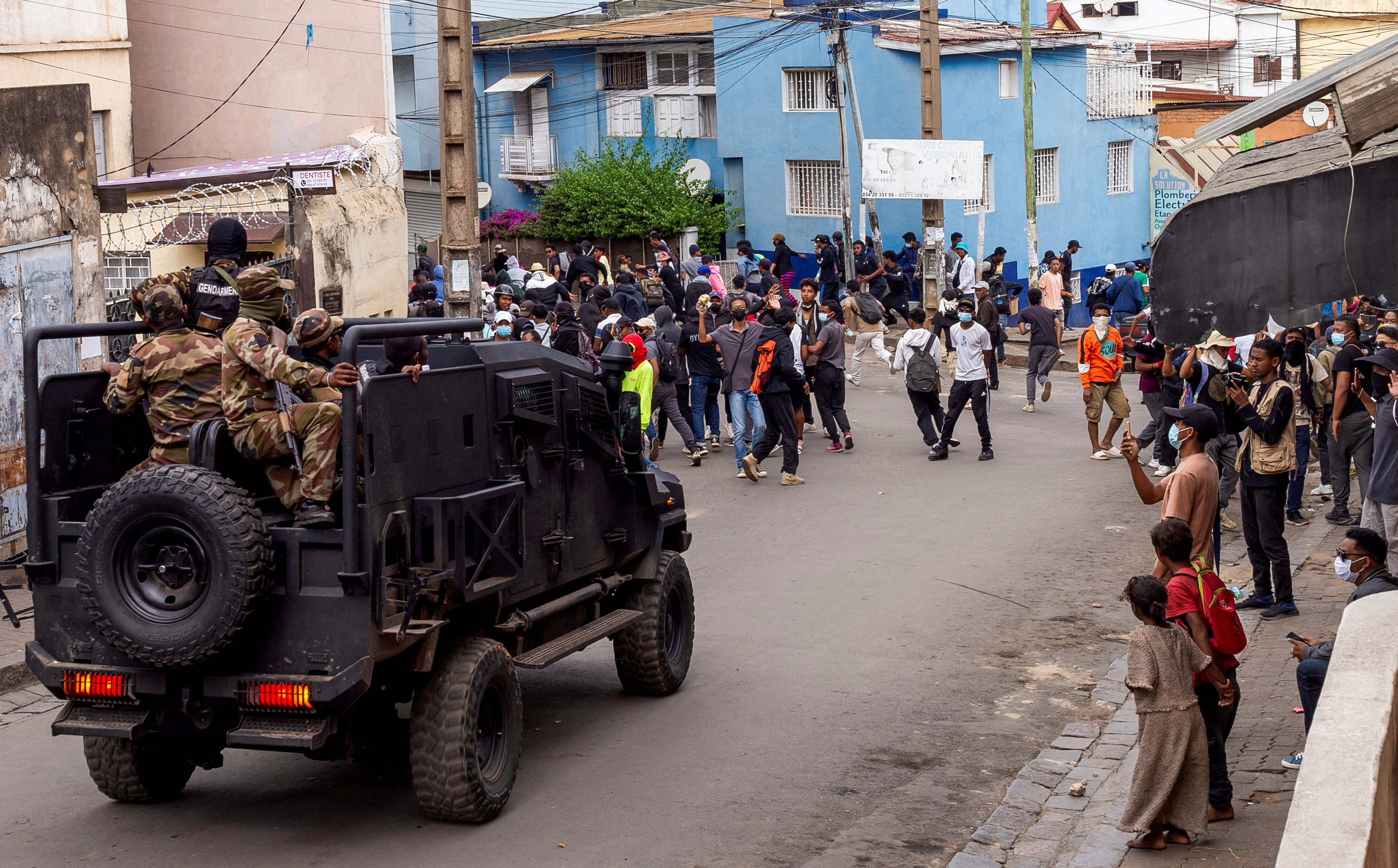 Protesters watch as riot police officers drive past during a demonstration against frequent power outages and water shortages, in the capital Antananarivo, Madagascar, October 1, 2025. (Reuters)
